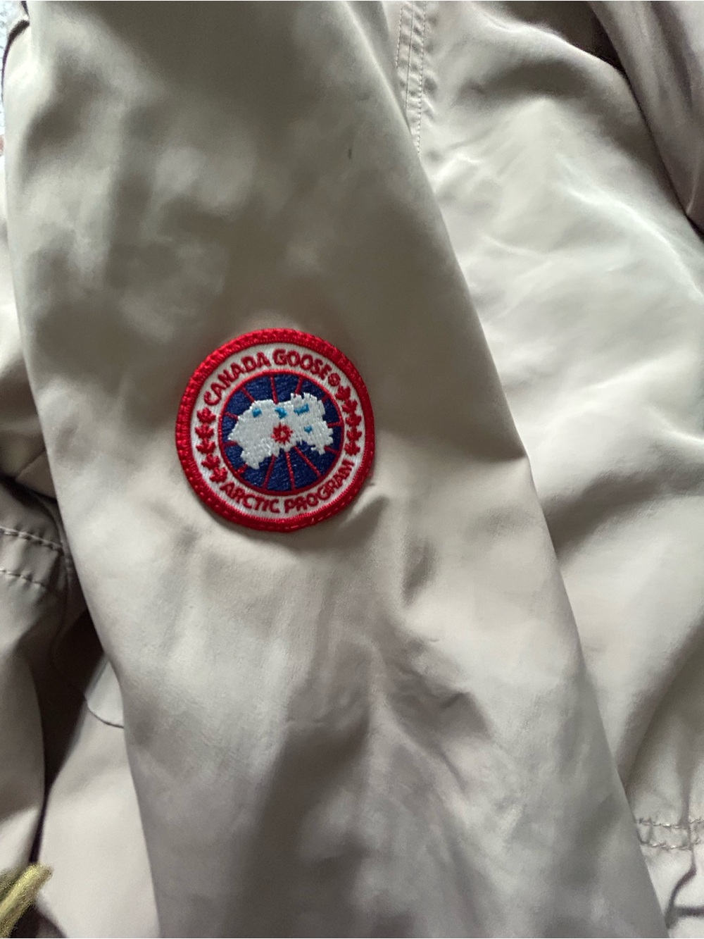 Canada Goose White Care Label with Red Tab Accents with small marks on sleeve.
